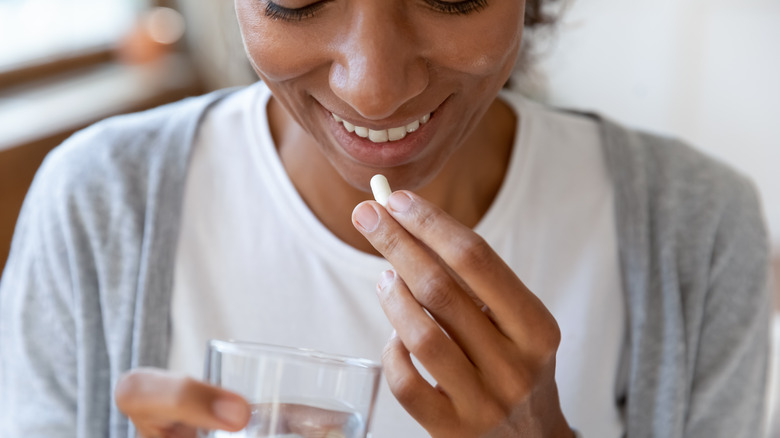  woman taking pill with water