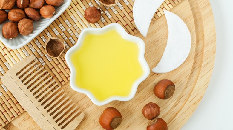 hazelnut oil in a dish surrounded by hazelnuts