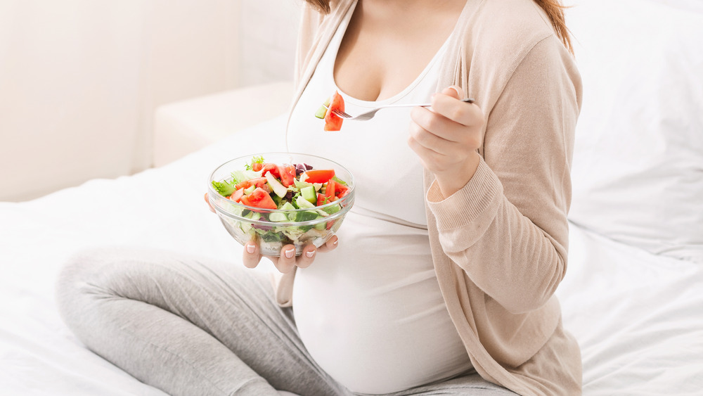 Pregnant woman eating salad