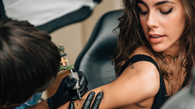 Woman getting tattoo on arm