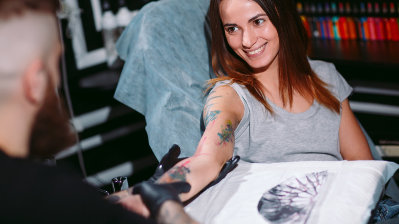 Woman being tattooed