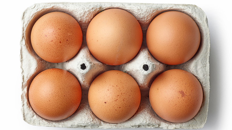 over head shot of egg carton with six eggs