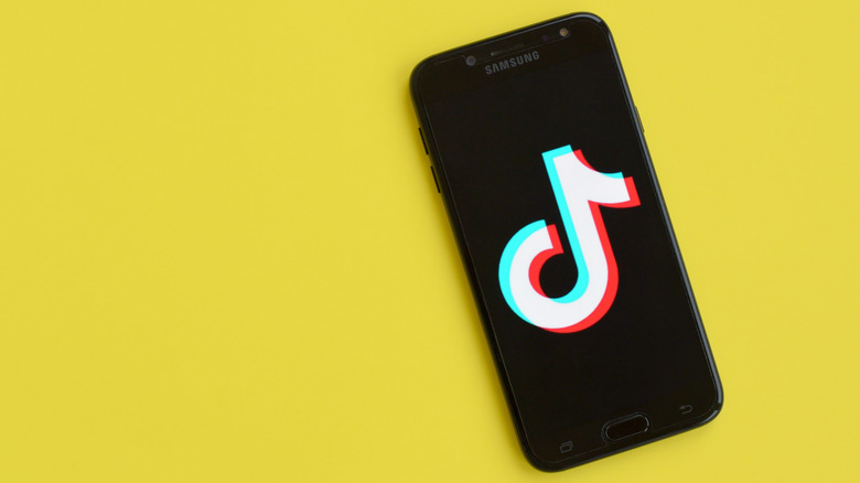 Phone with TikTok logo on yellow background