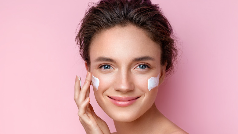 A woman applying moisturizer