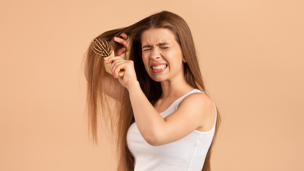 Girl brushing knotty hair