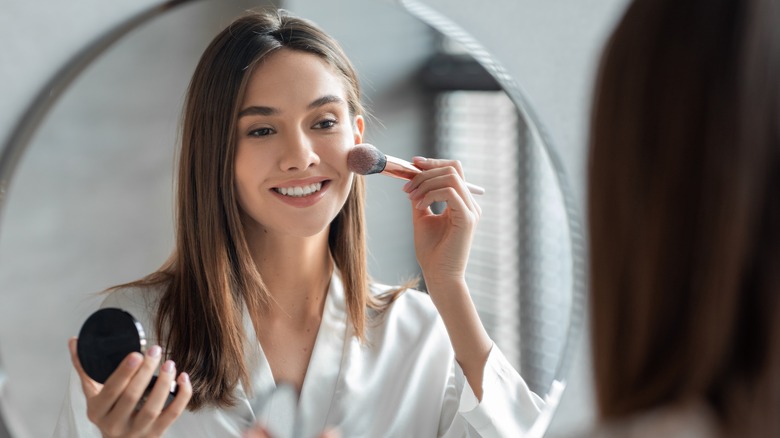 woman using a makeup brush 