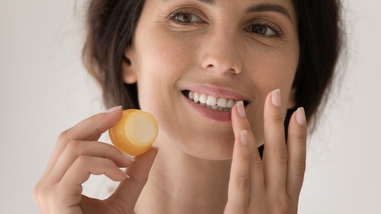 woman applying SPF to lips