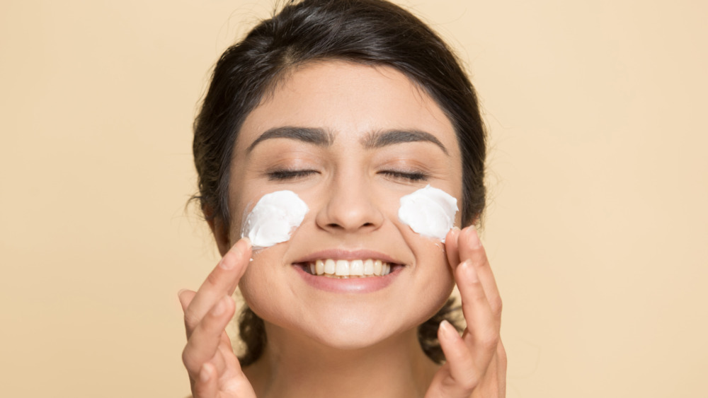 Woman Applying Cold Cream to Face in Bathroom