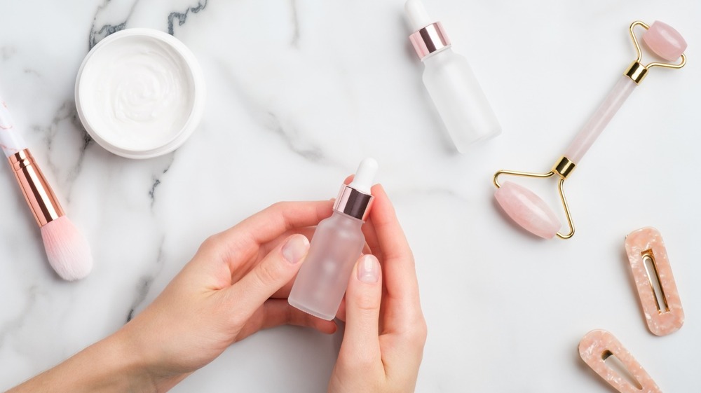 Woman holding a bottle of skin serum