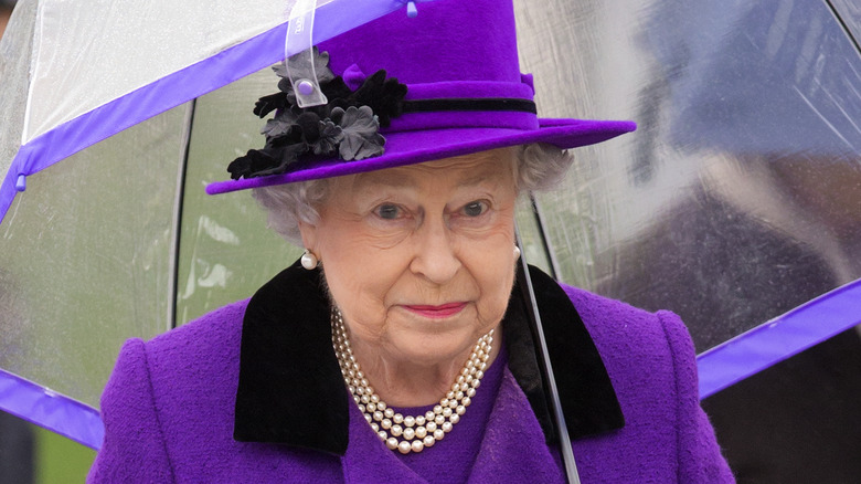 Queen Elizabeth holding an umbrella