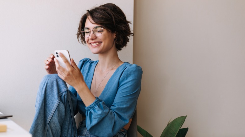 Woman smiling holding phone