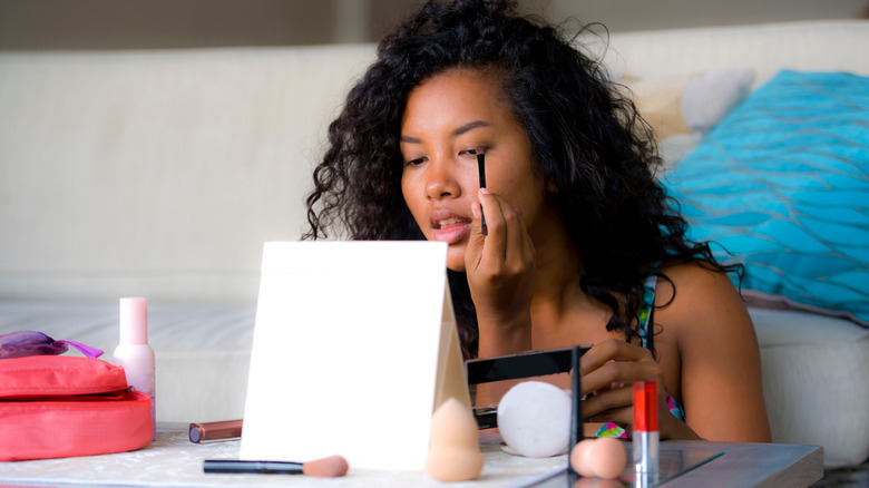 woman applying eyeliner with brush