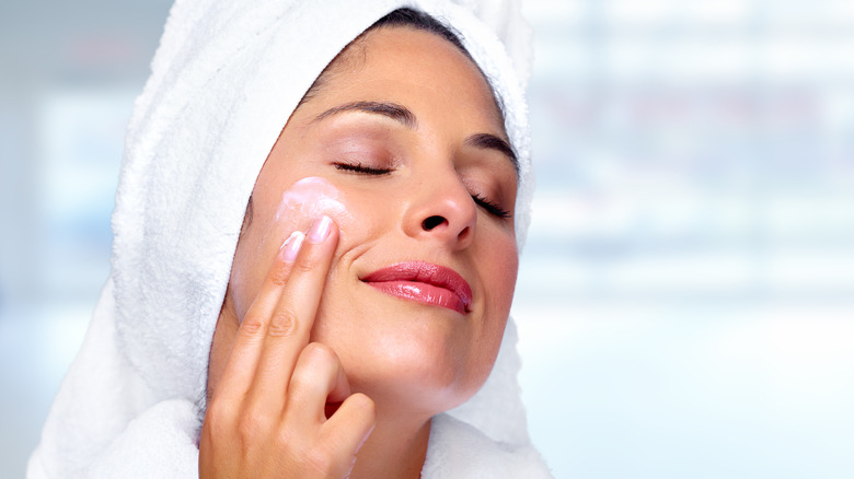 Woman putting on face cream