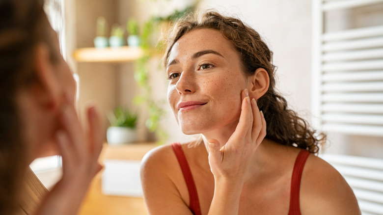 Woman looking in mirror smiling