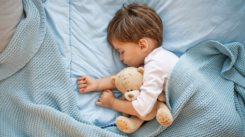 toddler napping with teddy bear