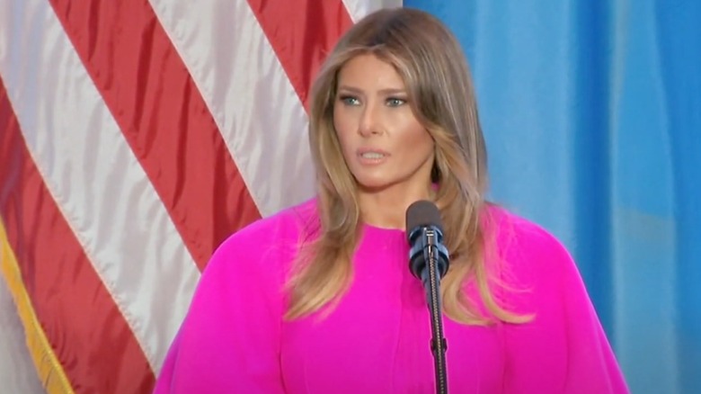 Melania Trump in pink standing at a podium.