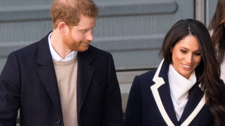 Meghan Markle holding Prince Harry's hand