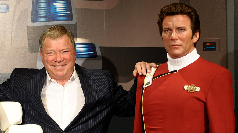 William Shatner standing next to a wax statue of himself as Captain Kirk.