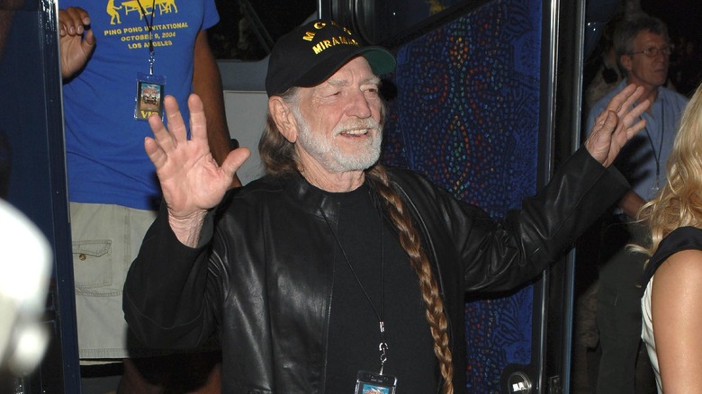 Willie Nelson greeting a crowd with a smile