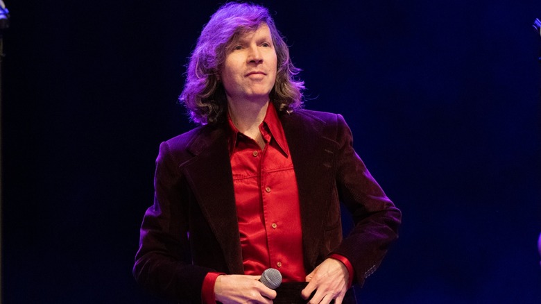 Beck up on stage holding a microphone during a performance