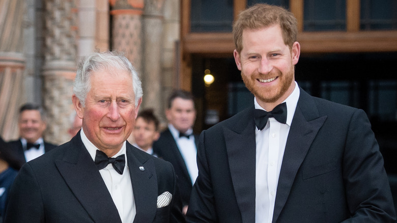 King Charles III and Prince Harry smiling