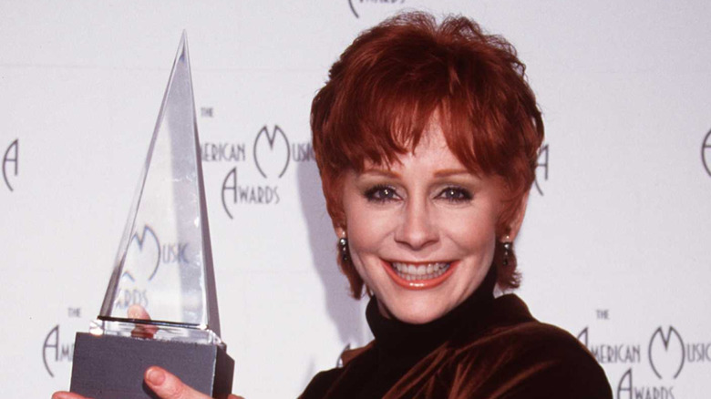 Reba McEntire holding up award