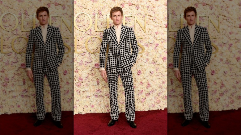 Eddie Redmayne posing on the red carpet at the 2025 Golden Globes