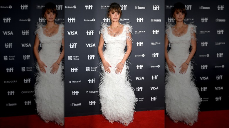 Penélope Cruz posing in a white feather-y dress on the red carpet