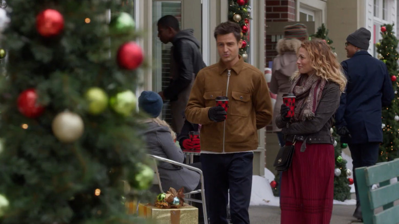 Two actors in An Unexpected Christmas walking down the street and staring at something over to their sides