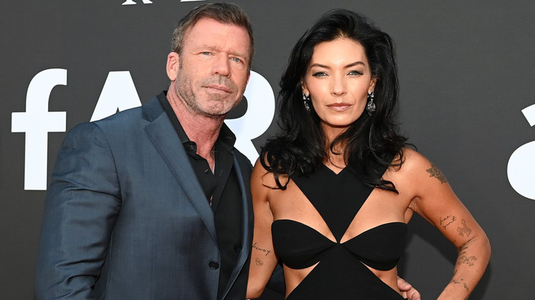 Taylor Sheridan posing beside his wife Nicole Muirbrook at an event