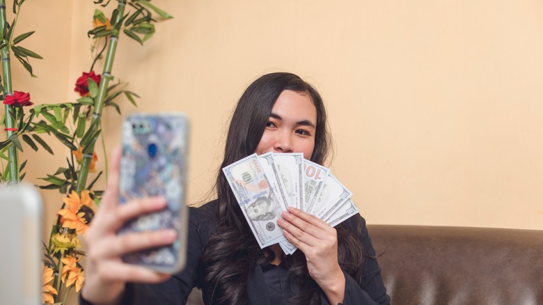 woman showing off cash