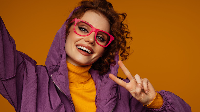 Woman in orange shirt and purple jacket