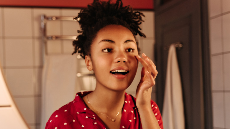 woman putting on eye cream