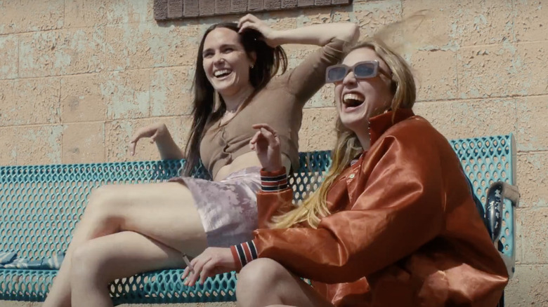 Eden Brolin sits on a bench laughing at a truck stop in "Candy Land"