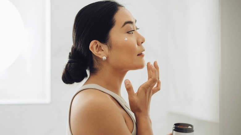 Woman applying moisturizer