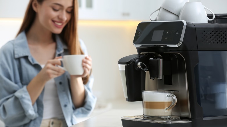 woman enjoying coffee and coffeemaker