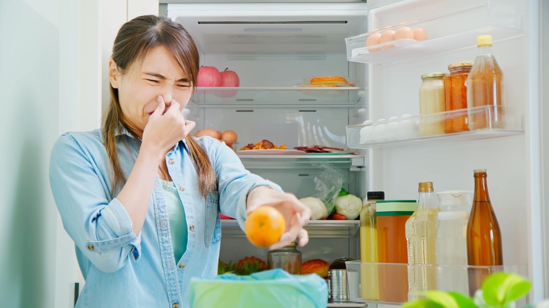 woman cleaning smelly fridge