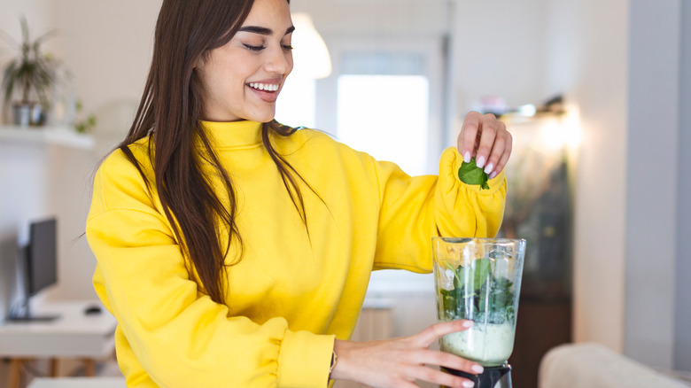 Woman preparing a smoothie in her blender