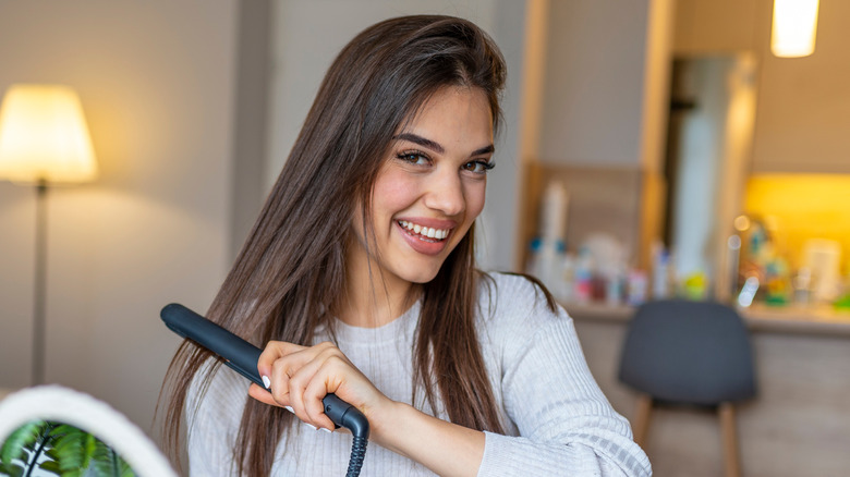 Woman with hair straightener