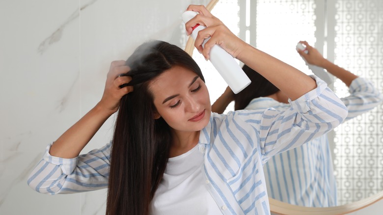 Woman spraying dry shampoo