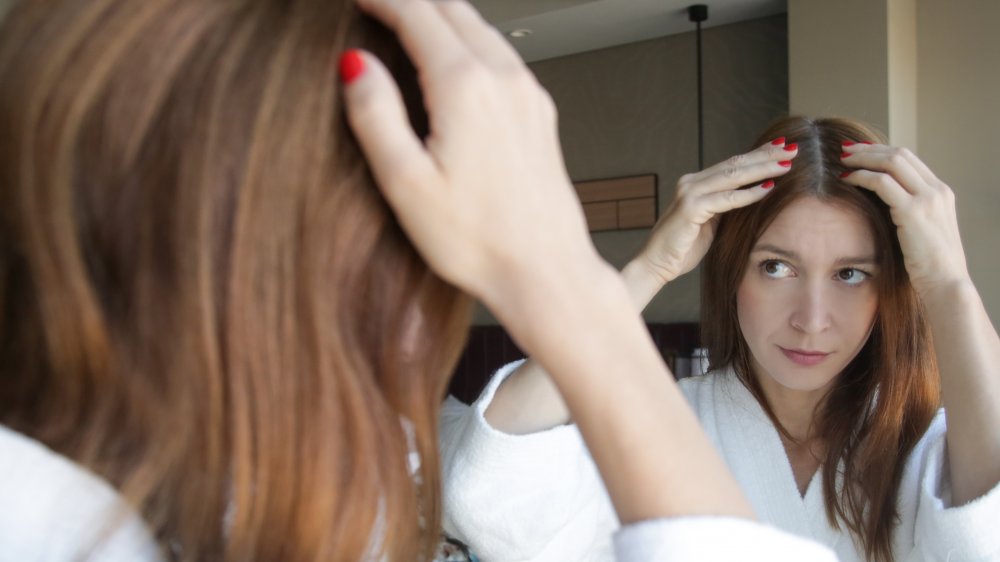 Woman examining scalp