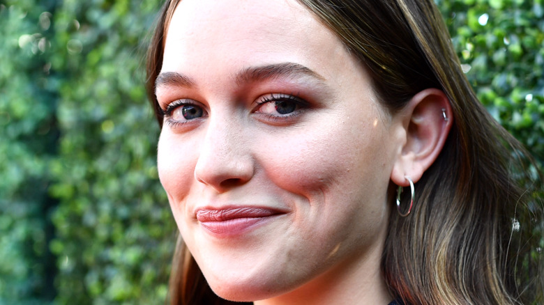 Victoria Pedretti standing in front of bushes on the red carpet