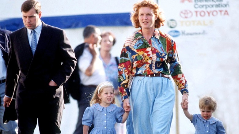 Prince Andrew walking alongside Sarah Ferguson, while she holds hands with Princesses Beatrice and Eugenie at the Royal Windsor Horse Show (1992)