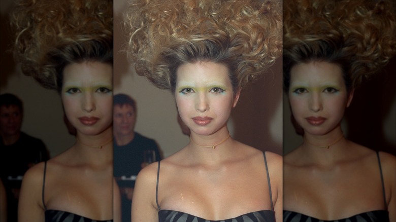 Ivanka Trump with bleached eyebrows, green eyeshadow, and her curly hair standing up on her head for fashion show