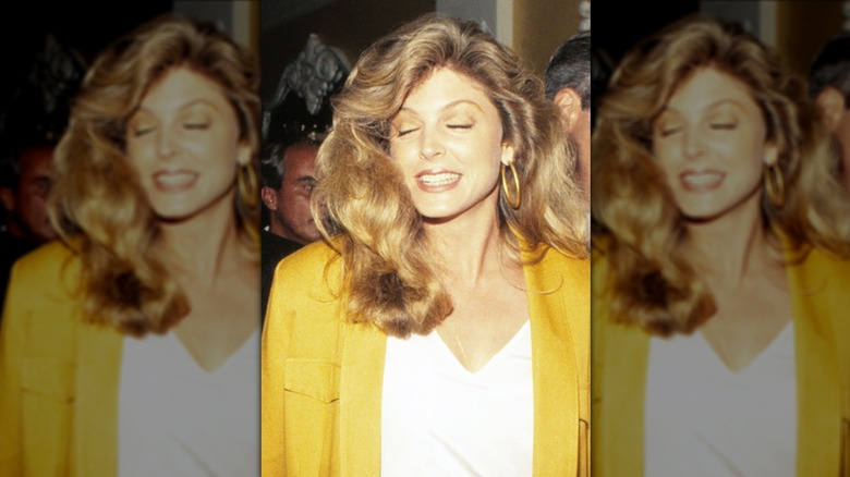 Marla Maples in 1990 smiling with eyes clothes, wearing a yellow blazer