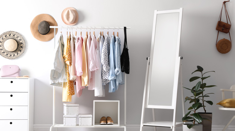 Room with a clothes rack, hats, shoes, and bags