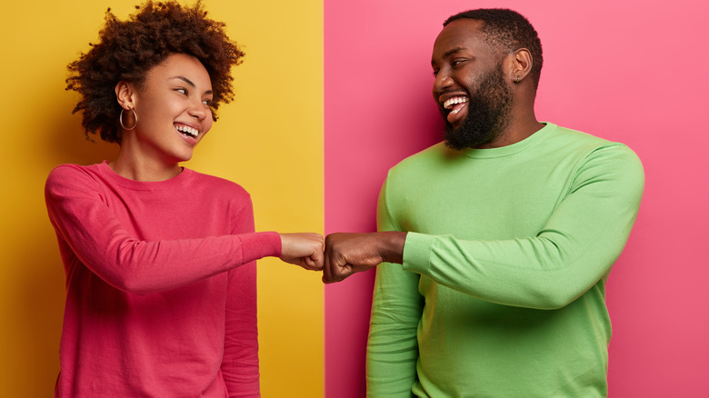 Man and woman in green and pink sweaters