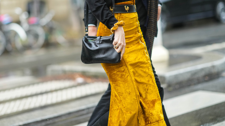 A mustard velvet skirt with black accessories