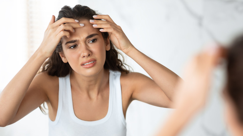 Woman looking at forehead acne