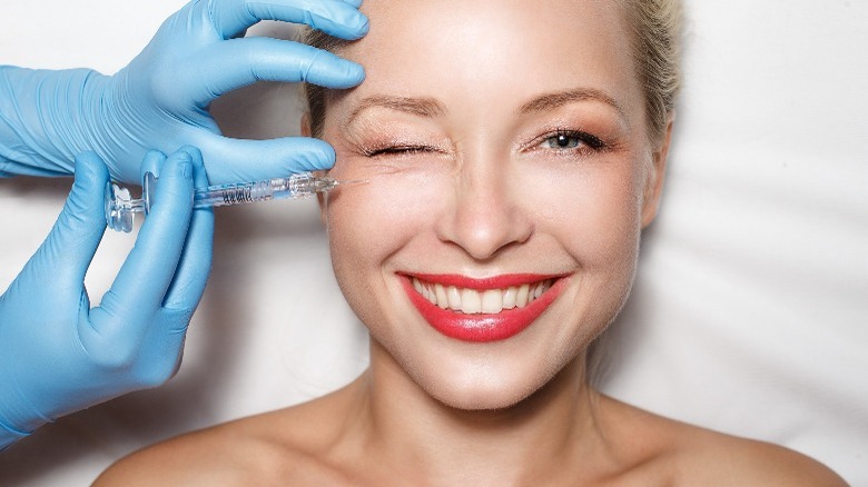Woman winks with facial injection